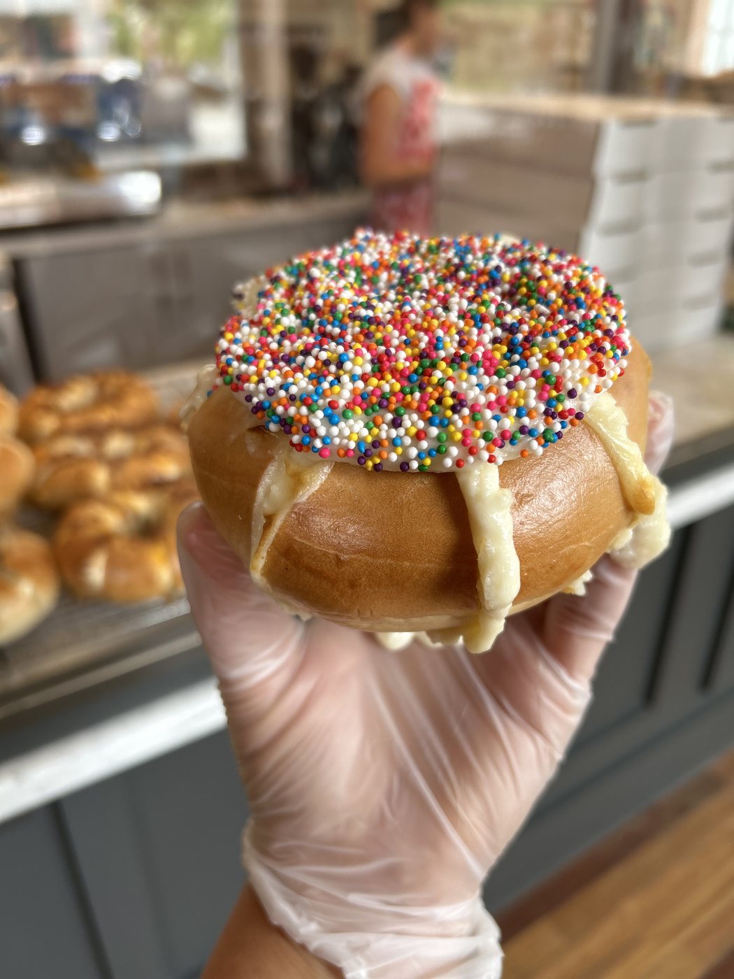Stuffed bagel topped with vanilla icing and rainbow sprinkles