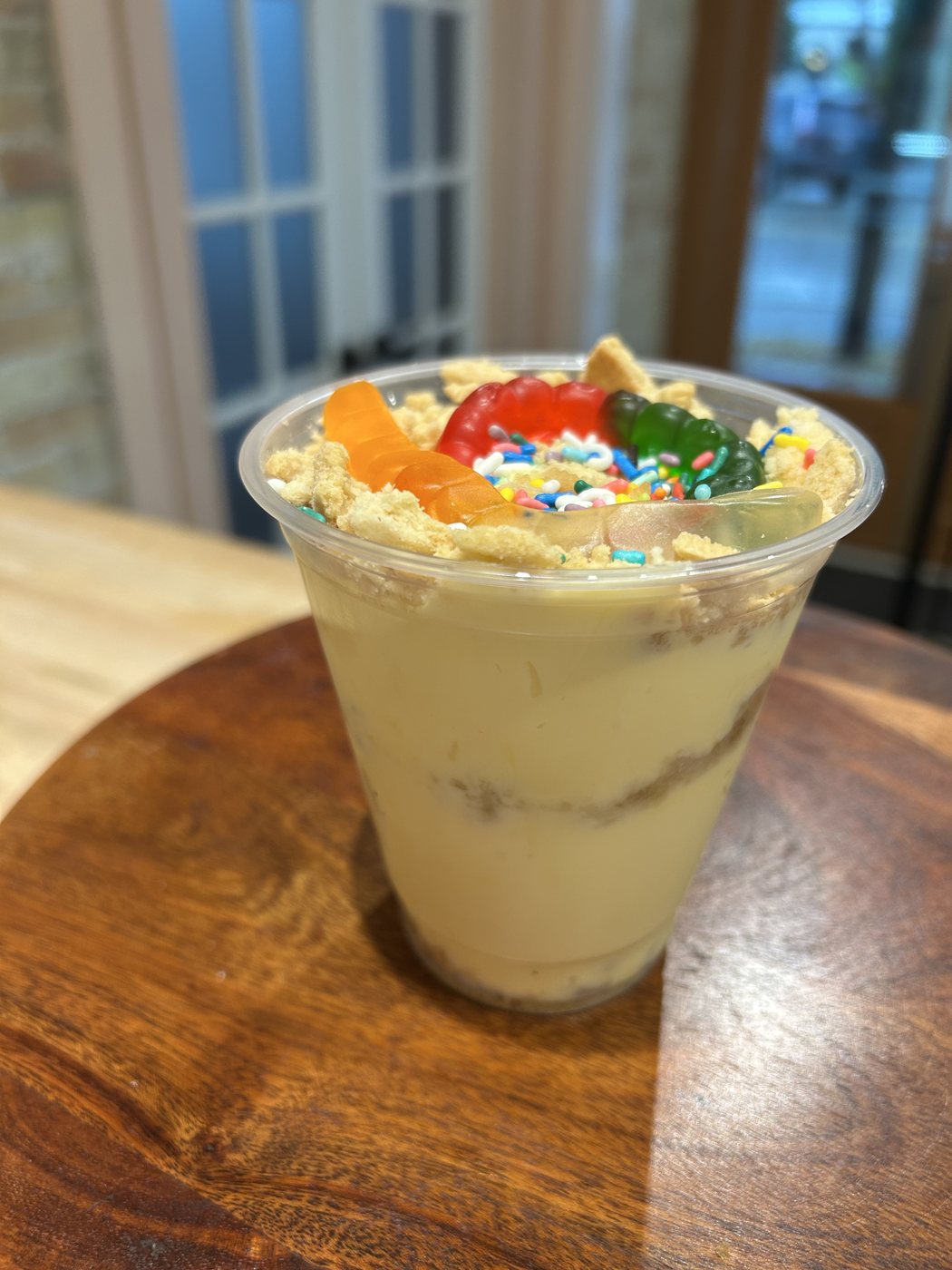 Vanilla Oreo dirt cake cup topped with sprinkles and gummy worms